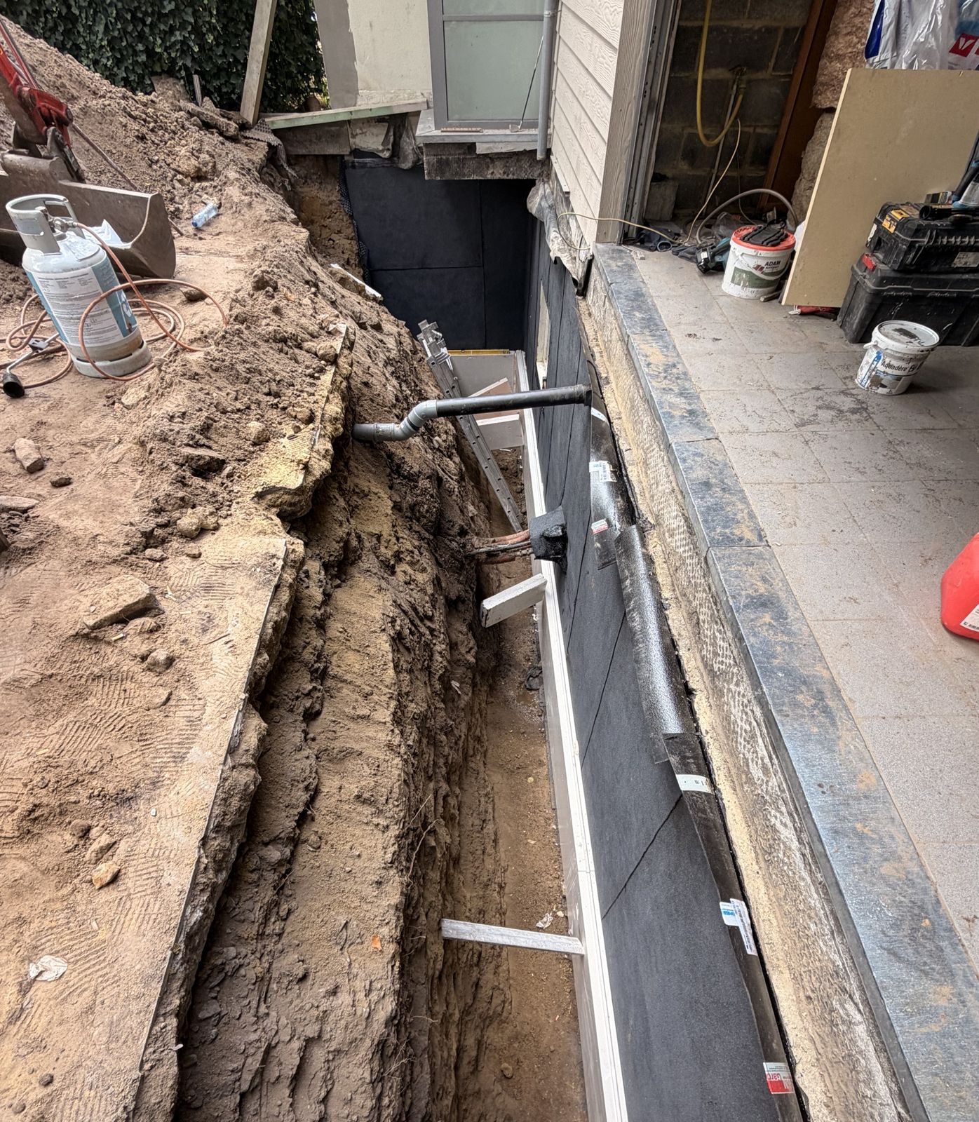 Tranchée creusée le long du mur de cave jusqu'aux fondations