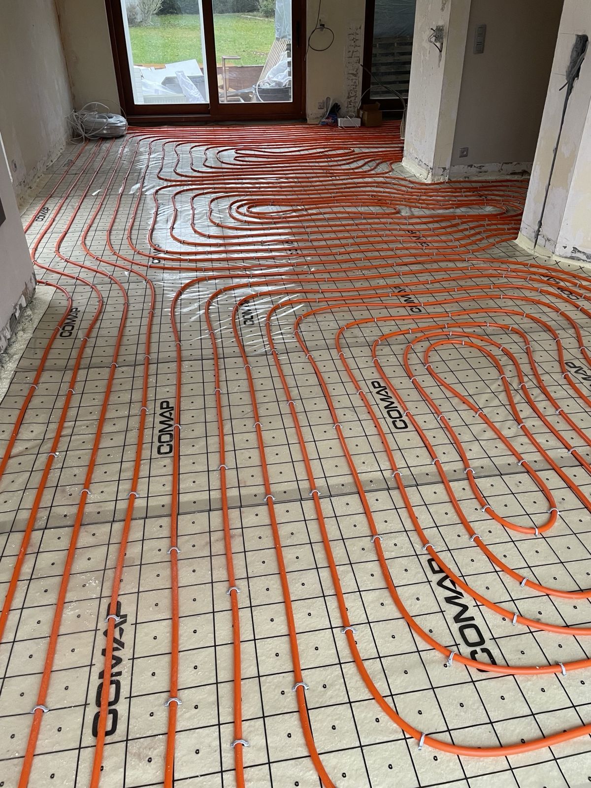 Tubes de chauffage par le sol posés en spirale sur isolant avant la chape