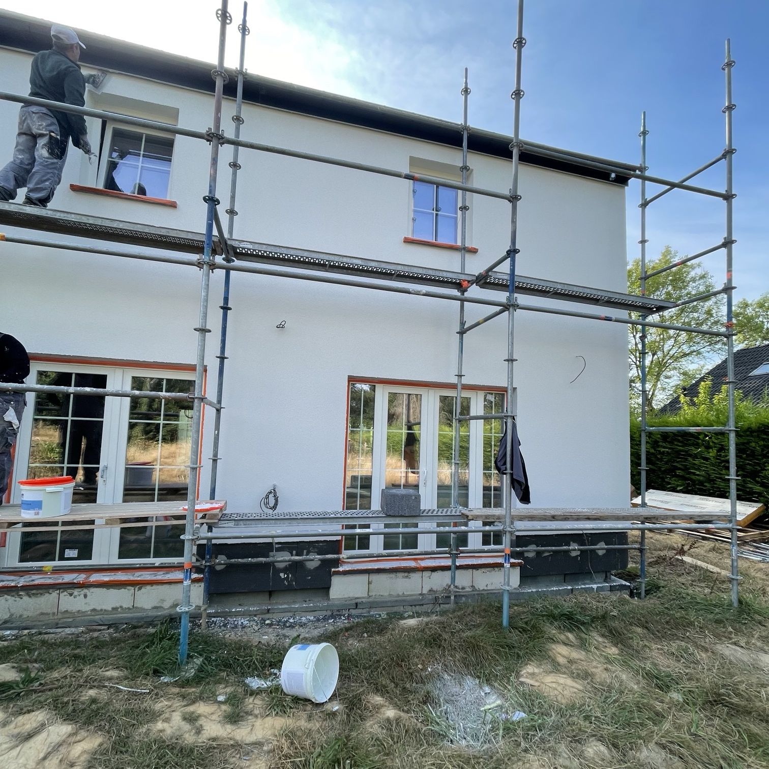 Façade enduite blanche avec châssis posés
