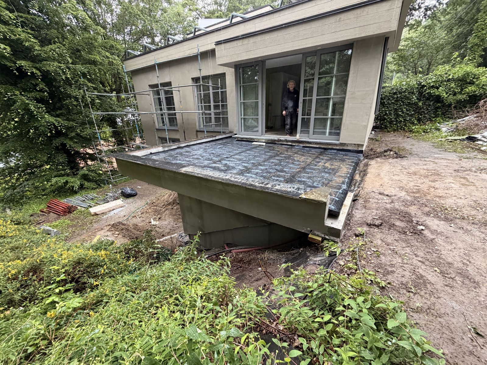 Terrasse en béton armé étanchée en porte-à-faux sur terrain en pente