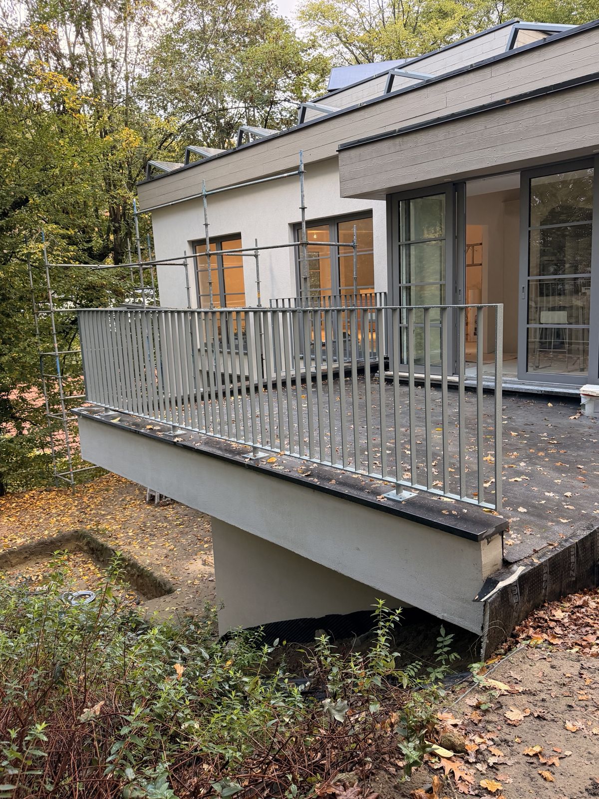 Terrasse en béton armé terminée à Overijse, enduite, avec garde-corps métallique
