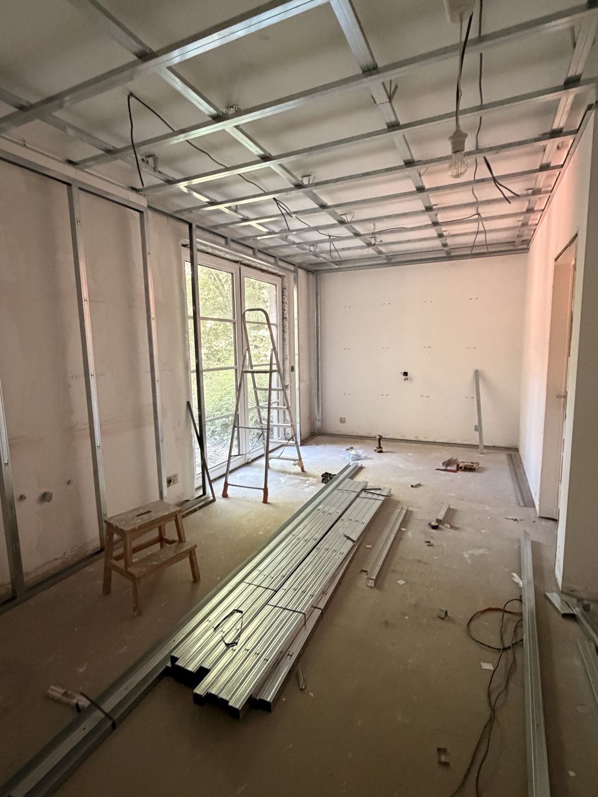 Ossature métallique de la contre-cloison posée sur les murs et le plafond d'une chambre à Kraainem